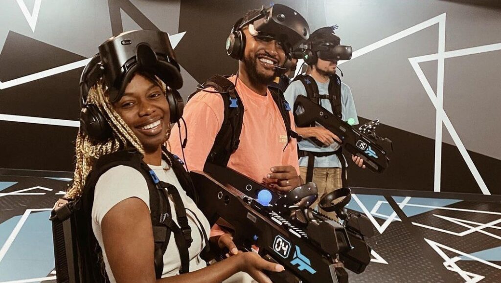 Équipe souriante s'apprêtant à jouer à un jeu de réalité virtuelle